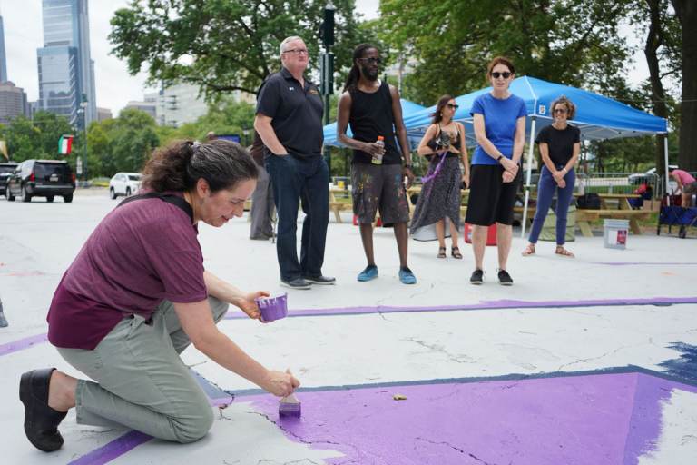Acting Health Commissioner Dr. Cheryl Bettigole paints as Mayor Jim Kenney speaks with artist, Felix St. Fort, and Mural Arts executive director Jane Golden. (Kenny Cooper / WHYY)