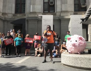 Shane Riggins, of Philadelphia Socialist Alternative, leads a protest by the group Tax The Rich PHL against proposed business tax cuts in the Philadelphia 2022 municipal budget. (Laura Benshoff/WHYY)