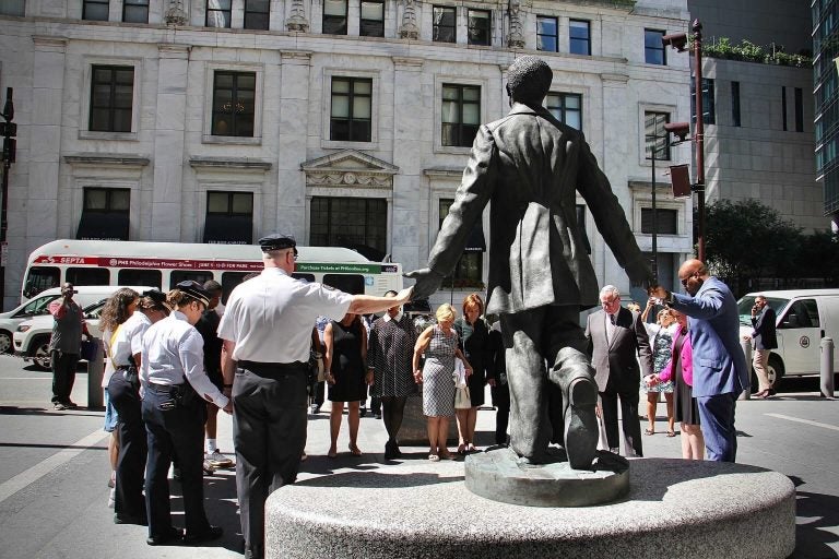 City officials and members of the Pathways to Reform, Transformation and Reconciliation steering committee join hands at the Octavius Catto statue for a moment of silence. The committee was formed after the murder of George Floyd and the civil unrest that followed. (Emma Lee/WHYY)