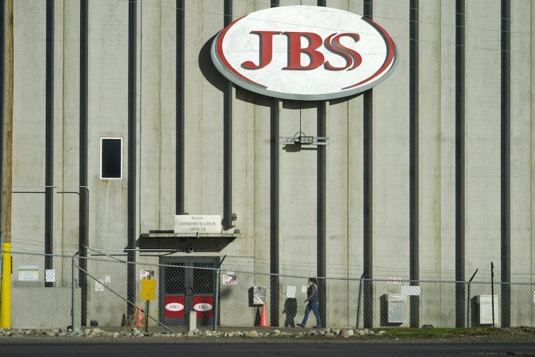 A worker heads into JBS meatpacking plant in Greeley, Colo.  A ransomware attack on the world's largest meat company is disrupting production around the world just weeks after a similar incident shut down a U.S. oil pipeline.  (AP Photo/David Zalubowski)