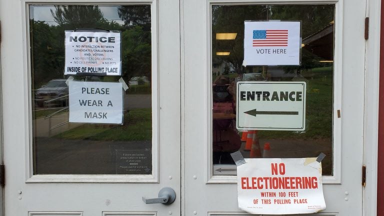 Doors to a N.J. polling station are covered in signs saying, 
