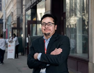 Steven Larín stands outside with his arms folded