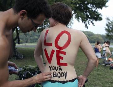 Cheryl Rehmann has a message painted on her back that says, 