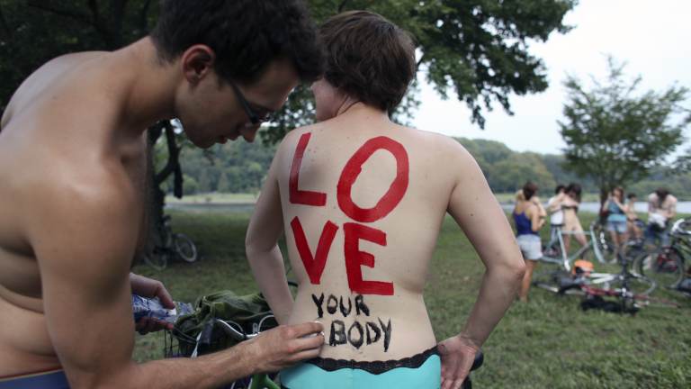 Cheryl Rehmann has a message painted on her back that says, 