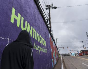 A pedestrian walks past a mural in Huntington, W.Va., Thursday, March 18, 2021. Huntington was once ground-zero for this opioid epidemic. Several years ago, they formed a team that within days visits everyone who overdoses to try to pull them back from the brink. It was a hard-fought battle, but it worked. The county's overdose rate plummeted. They wrestled down an HIV cluster. They finally felt hope. Then the pandemic arrived and it undid much of their effort: overdoses shot up again, so did HIV diagnoses. (AP Photo/David Goldman)