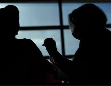 A person receives a COVID-19 vaccination from a nurse practitioner