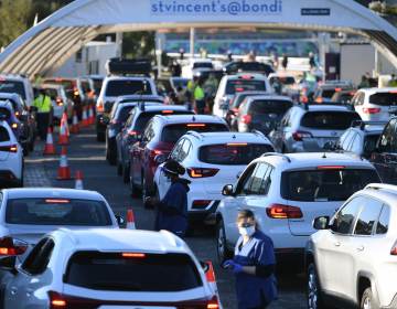 People line up in their cars to get tested for COVID-19 at a pop-up testing clinic at Bondi Beach in Sydney on Friday. Parts of Sydney will go into lockdown late Friday because of a growing coronavirus outbreak in Australia's largest city. (Dean Lewins/AP)