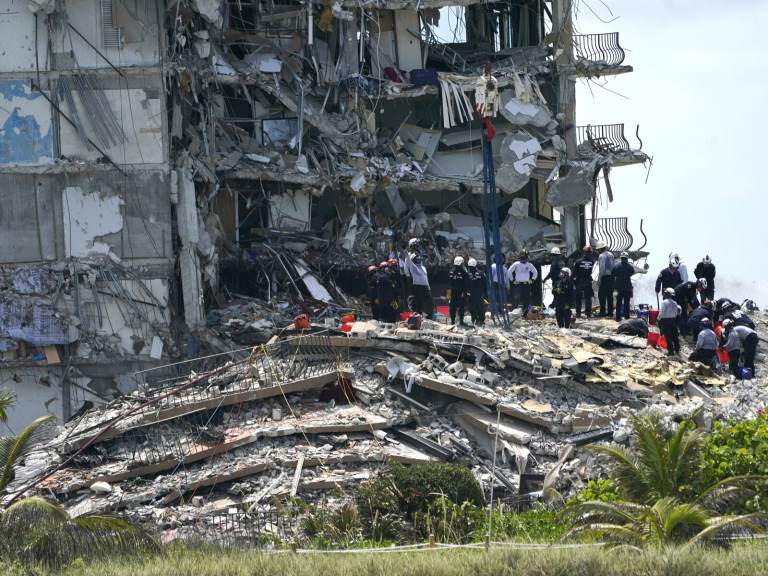 Rescue workers search in the rubble at the Champlain Towers South condominium