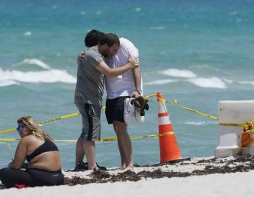 Building Collapse Miami Two men console each other on the beach