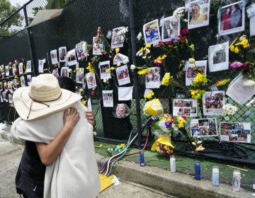 People embrace at a make-shift memorial