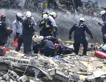 Rescue workers search the rubble of the Champlain Towers South condominium