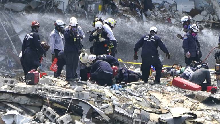 Rescue workers search the rubble of the Champlain Towers South condominium