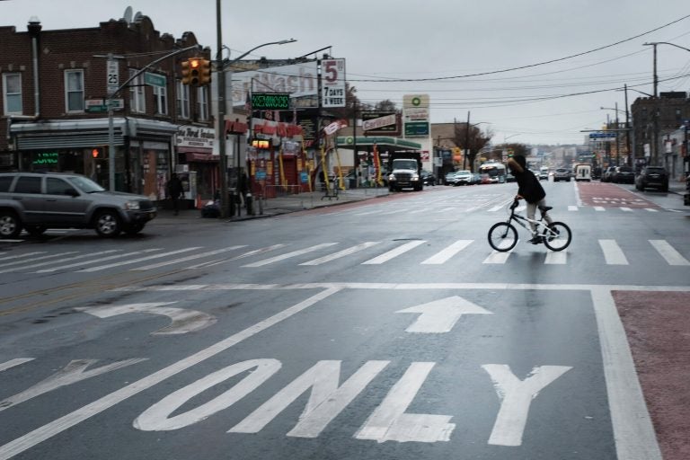 A person rides a bike across a New York street