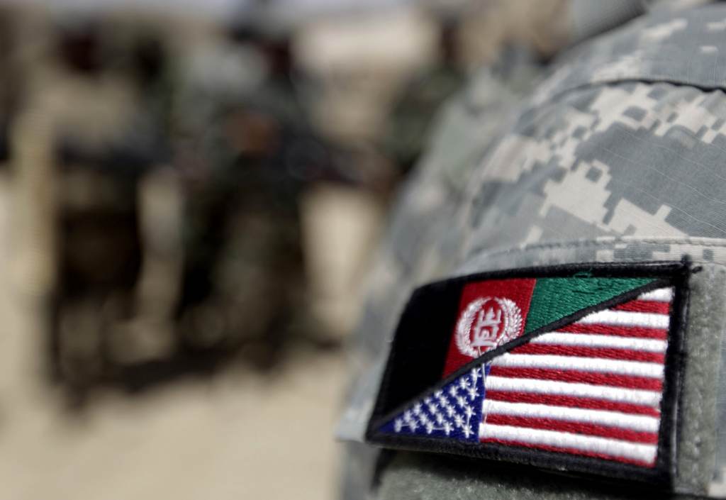 An Afghan interpreter working with the 101st Airborne Division Alpha Battery 1-320th displays a patch showing the Afghan and US flags at Combat Outpost Nolen on the outskirts of Arghandab valley's Jellawar town