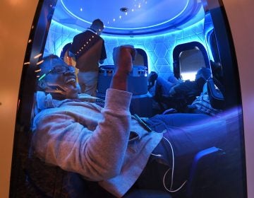 Participants sit a Blue Origin space simulator during a conference on robotics and artificial intelligence in Las Vegas on June 5, 2019. On Saturday, Blue Origin announced that an unidentified bidder will pay $28 million for a suborbital flight on the company's New Shepard vehicle. (Mark Ralston/AFP via Getty Images)