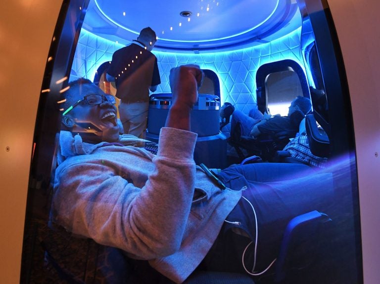 Participants sit a Blue Origin space simulator during a conference on robotics and artificial intelligence in Las Vegas on June 5, 2019. On Saturday, Blue Origin announced that an unidentified bidder will pay $28 million for a suborbital flight on the company's New Shepard vehicle. (Mark Ralston/AFP via Getty Images)