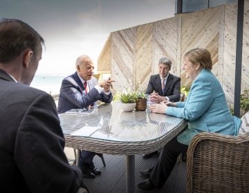 Chancellor Angela Merkel and US President Joe Biden speak while sitting at a table