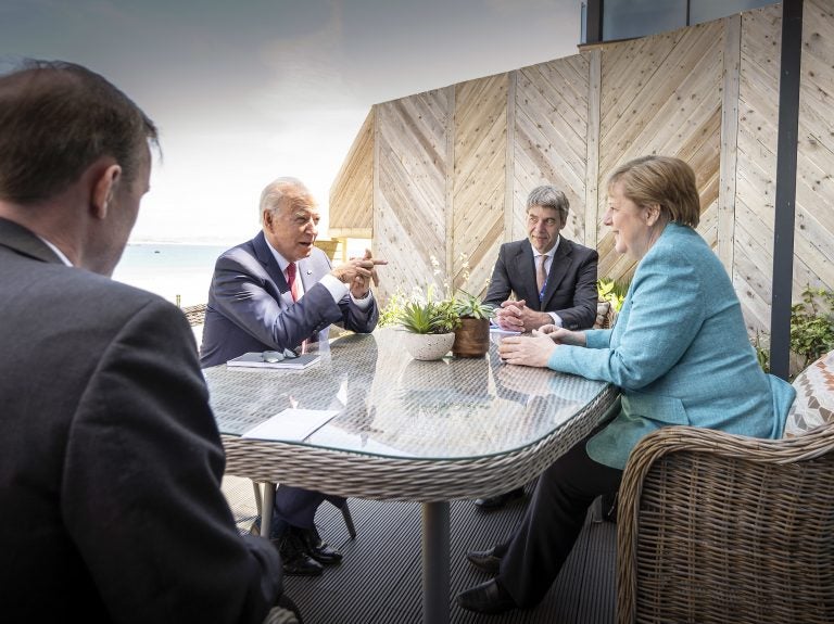 Chancellor Angela Merkel and US President Joe Biden speak while sitting at a table