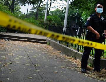 A police officer stands near crime scene tape