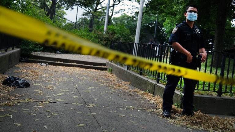 A police officer stands near crime scene tape