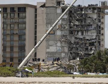 Members of the South Florida Urban Search and Rescue team look for possible survivors in the partially collapsed 12-story Champlain Towers South condo building