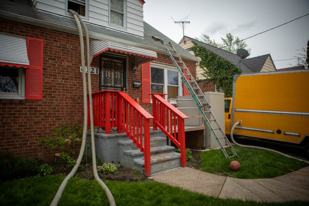 The exterior of a home, with a ladder leading to the roof