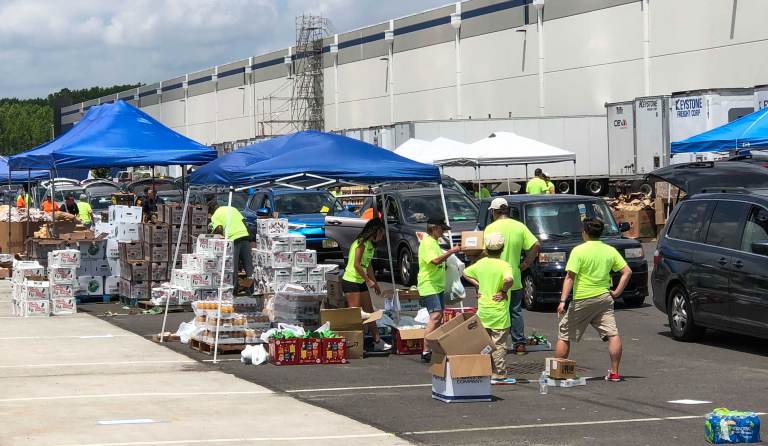 Volunteers load groceries into vehicles during a food distribution event