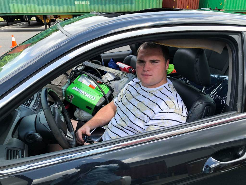 William Raymond sits inside his car