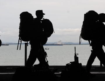 The silhouettes of military service members are pictured.