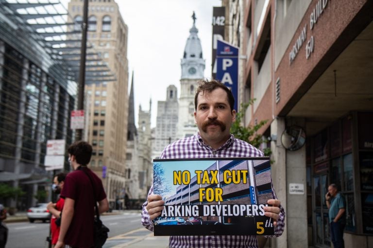 Daniel Trubman holds up a sign that says, 