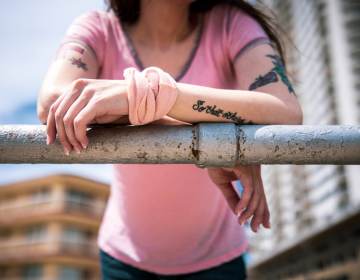 Sonia Doe is pictured, faceless, standing at a railing