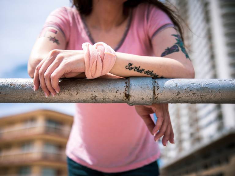 Sonia Doe is pictured, faceless, standing at a railing