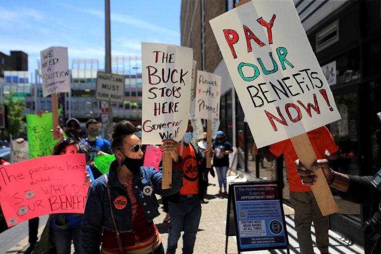 People hold signs that say, 