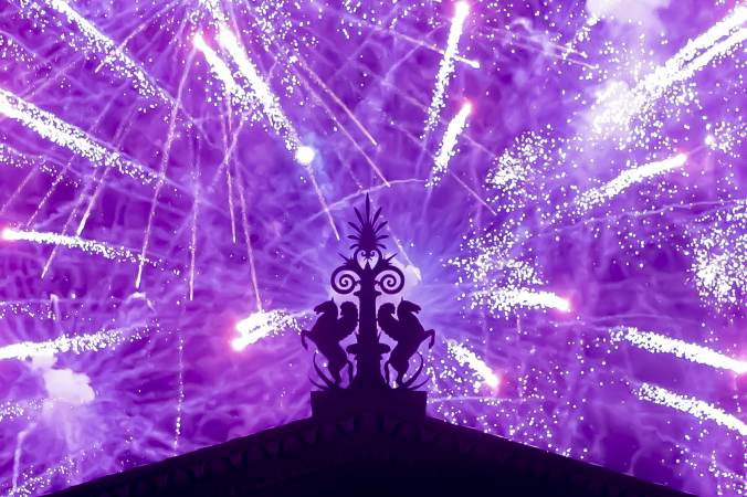 Fireworks explode in the background behind a gargoyle atop of the central portico of the Philadelphia Museum of Art. (Jonathan Wilson for WHYY)