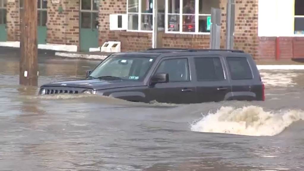 Aa car is pictured in heavy floodwaters