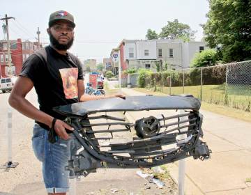 De'Wayne Drummond picks up a grill left behind after a crash at 34th Street and Mantua Avenue