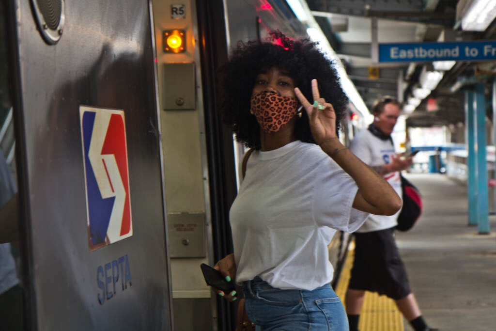Tykira Octavia throws up a peace sign as she boards a Market-Frankford Line train