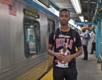 Elijah Brown stands next to a Market-Frankford line train inside Girard Station