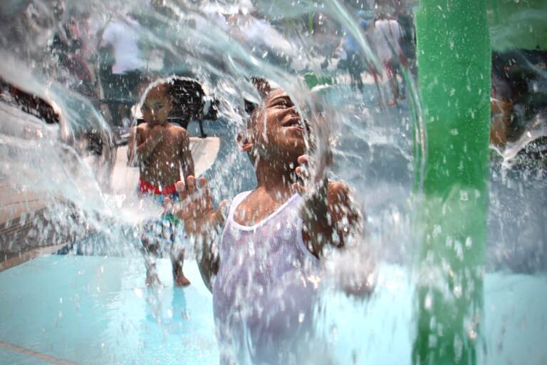 Mesiah Clark splashes around at a sprayground in Philly