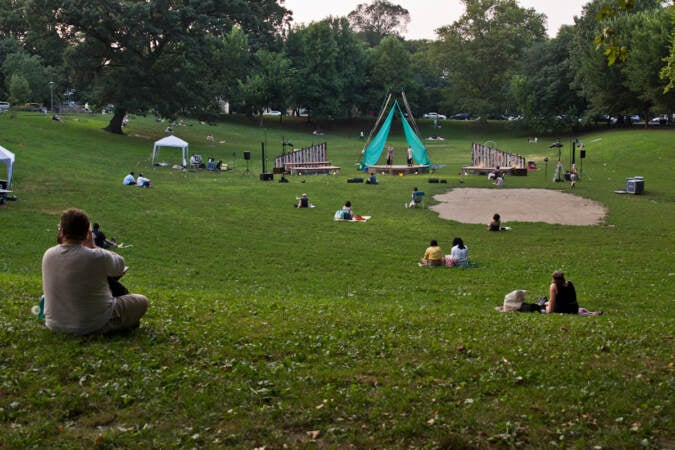 People sit outside at Clark Park to watch a Shakespeare play