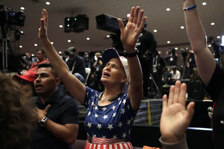 Wanda Albritton, of Miami Springs, Fla., raises her ams in prayer during a rally for evangelical supporters at the King Jesus International Ministry church, Friday, Jan. 3, 2020, in Miami. (AP Photo/Lynne Sladky)