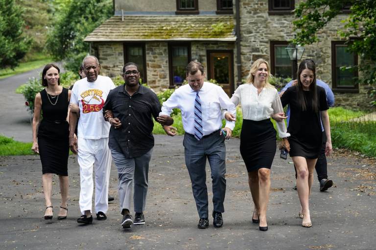 Bill Cosby, second left, and spokesperson Andrew Wyatt, third left, approach members of the media gathered outside Cosby's home in Elkins Park, Pa., Wednesday, June 30, 2021, after Pennsylvania's highest court overturned his sex assault conviction. (AP Photo/Matt Rourke)