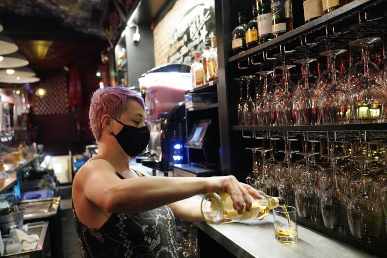 Erin Bellard pours a drink for a customer at her bar