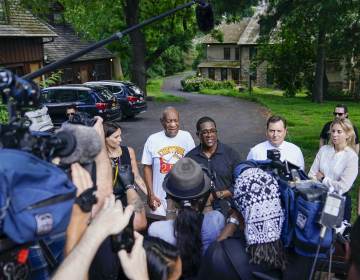 Bill Cosby, center, and spokesperson Andrew Wyatt, right, approach members of the media