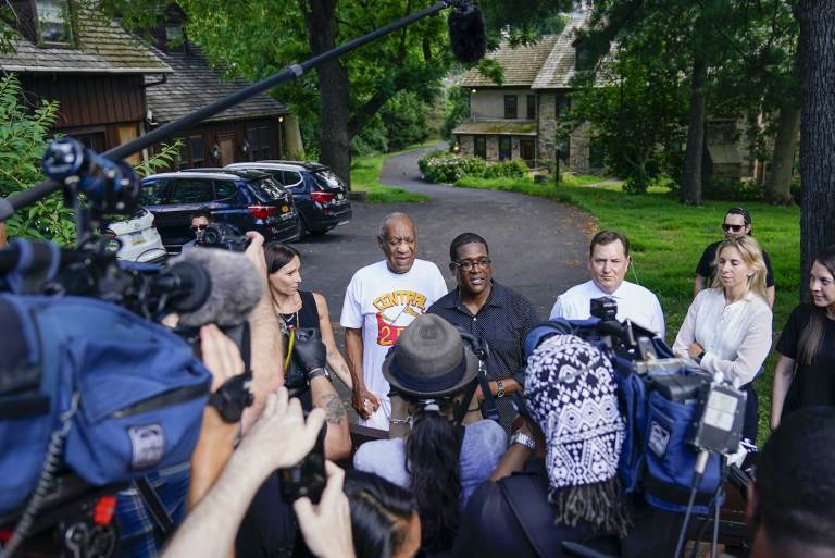 Bill Cosby, center, and spokesperson Andrew Wyatt, right, approach members of the media