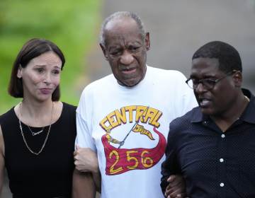 Bill Cosby, center, and spokesperson Andrew Wyatt, right, approach members of the media