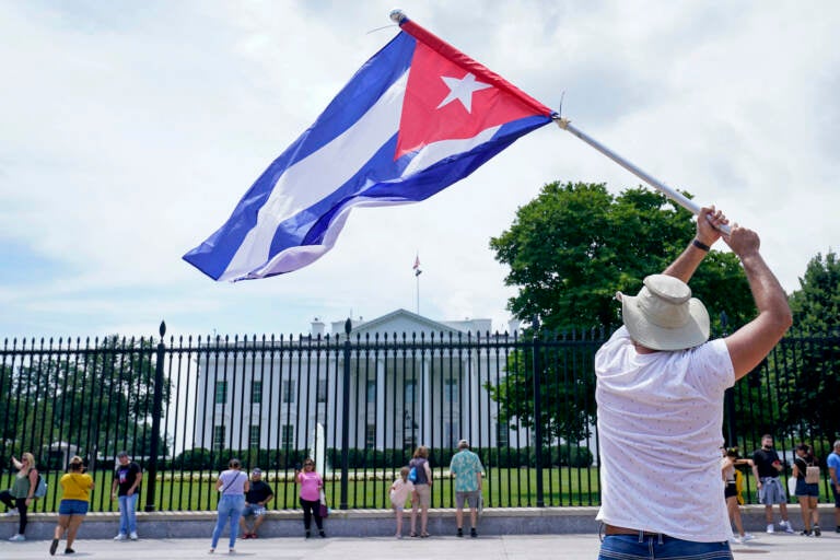 A person flies a Cuban flag outside the White House