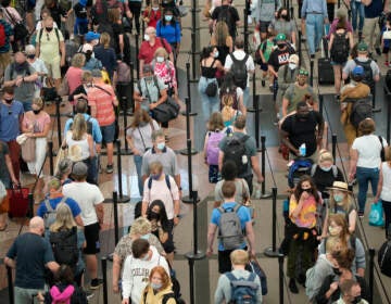 Travelers queue up in long lines to pass through an airport security checkpoint