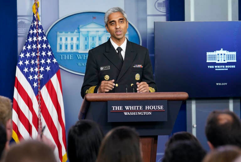 Surgeon General Dr. Vivek Murthy speaks from a podium at the White House briefing room