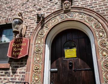 A sign posted on the door of the Regina Rose Apartments in Elkins Park, Pa., warns of structural danger. (Kimberly Paynter/WHYY)